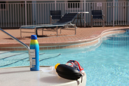 a bottle of sunscreen next to a swimming pool