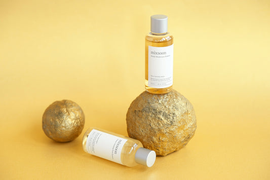 Skincare products are displayed on a gold surface.