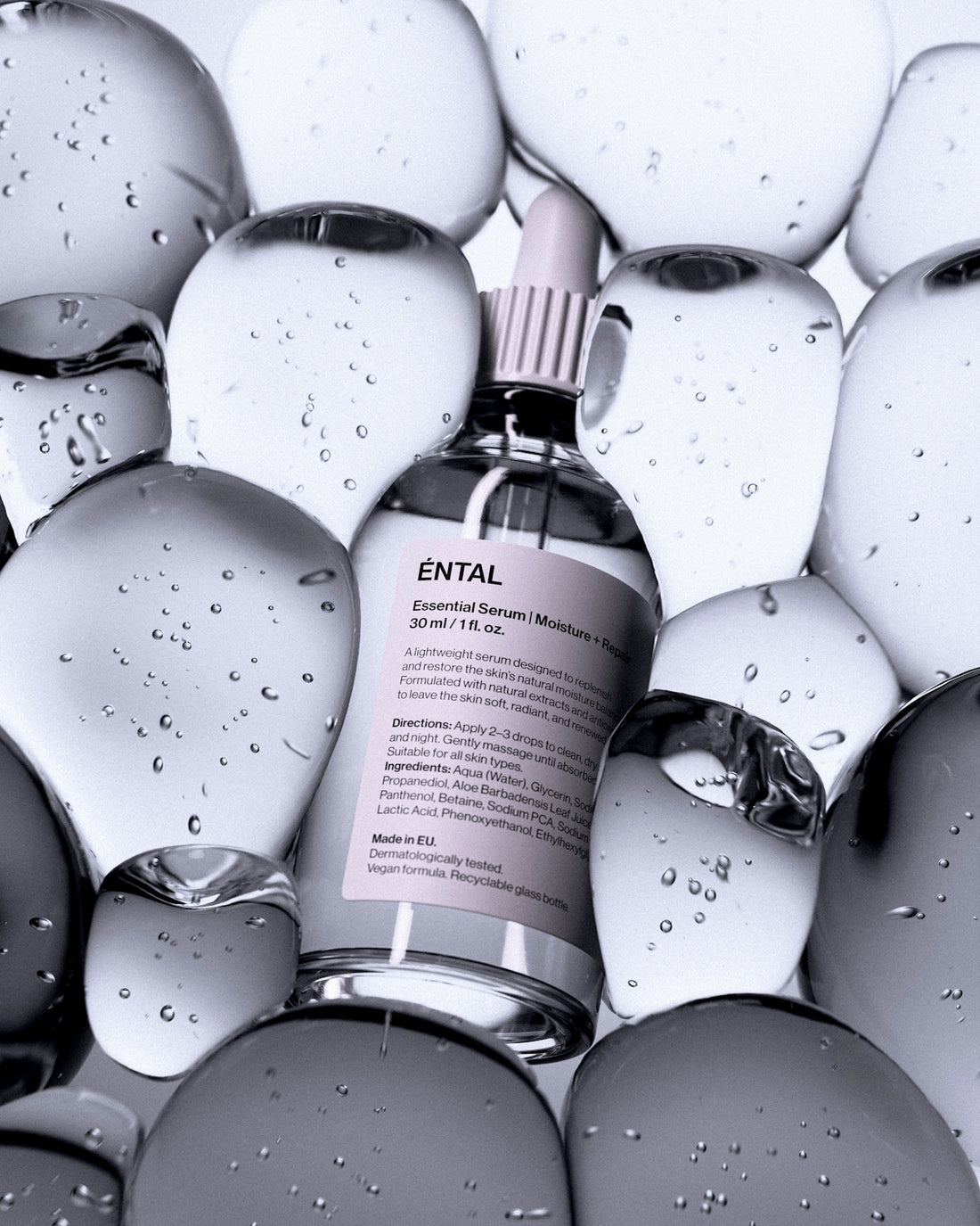 A bottle of serum surrounded by clear, rounded shapes.