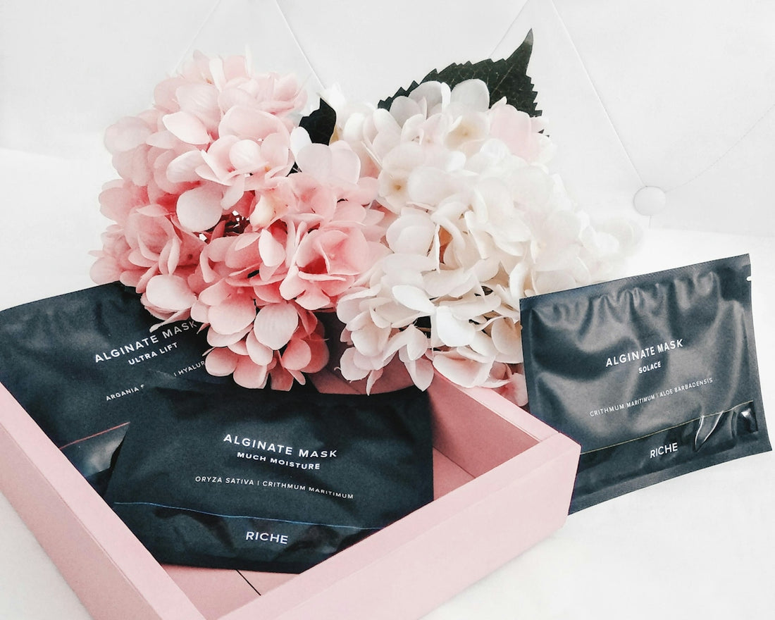 Skincare packages and flowers in a pink tray