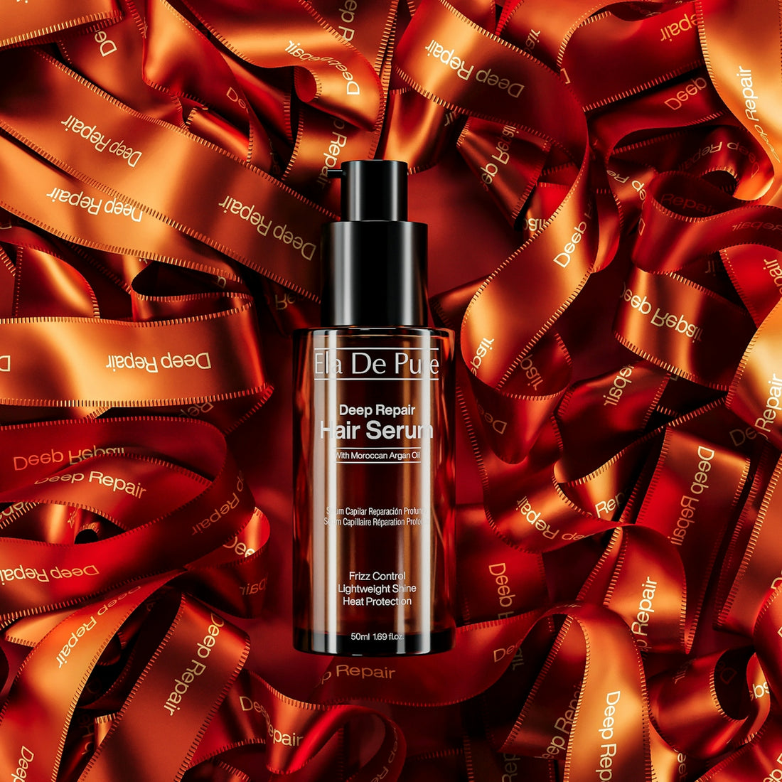 A bottle of hair serum rests on tangled orange ribbons.