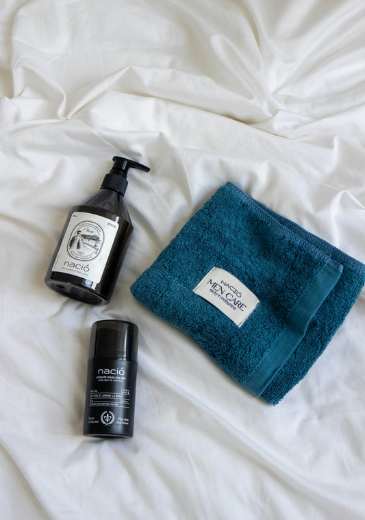 Skincare products and a blue towel on white bedding