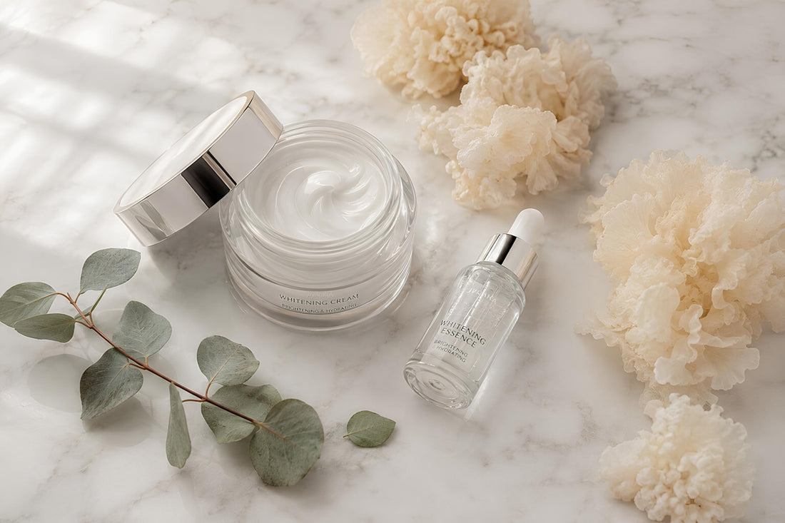 Skincare cream, serum, eucalyptus, and fluffy elements on marble.